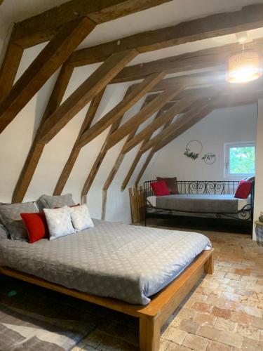 Ce lit se trouve dans un dortoir doté de poutres apparentes. dans l'établissement La Grange d Ave, à Luynes