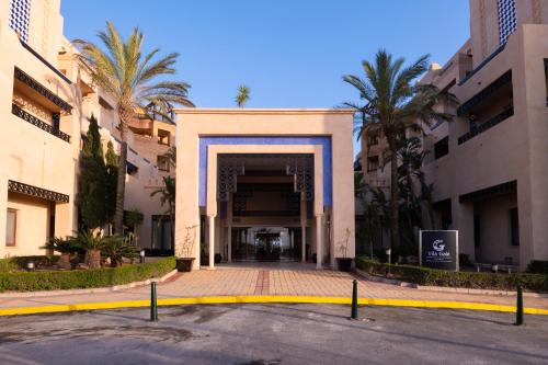 an entrance to a building with palm trees in front at Vila Gale Isla Canela in Isla Canela