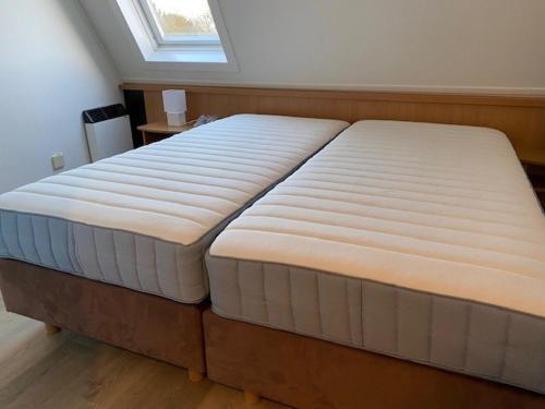 ホルムにあるAppartement Eb en Vloedの窓のある部屋にある大きなマットレスベッド