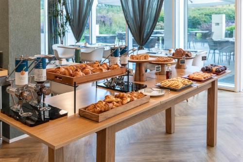 a table with various pastries and breads on it at MO.OM Hotel in Olgiate Olona
