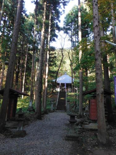 a path through a forest with a tent in the background at Yamagata Kokusai Hotel in Yamagata