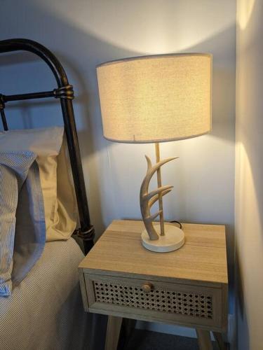 a lamp on a night stand next to a bed at Luxurious Georgian Town House in Langholm