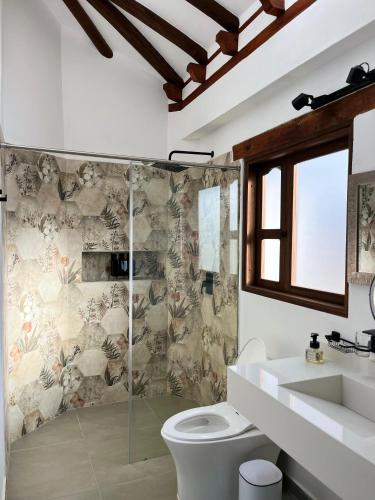 a bathroom with a shower and a toilet and a sink at Hotel Vista Montaña in Villa de Leyva