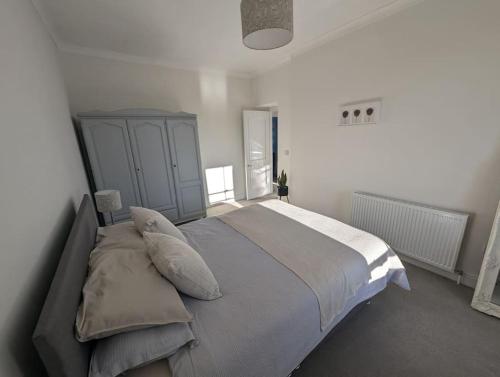a bedroom with a large bed with pillows on it at Luxurious Georgian Town House in Langholm