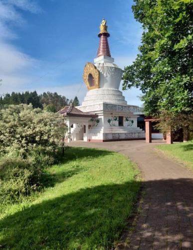 a large white building with a pagoda in a park at Luxurious Georgian Town House in Langholm