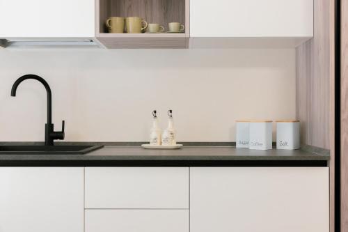 una cucina con mobili bianchi e un lavello di Nova Ulpia a Volpiano