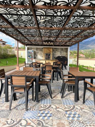 a patio with wooden tables and chairs and a fireplace at Hotel Vista Montaña in Villa de Leyva
