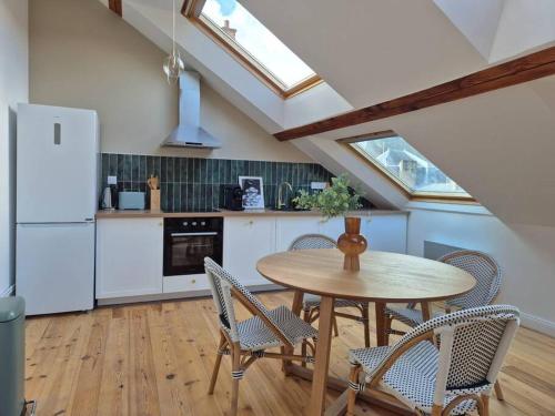 une cuisine avec une table, des chaises et un réfrigérateur dans l'établissement Poreč, Appartement lumineux vue sur la Cathédrale, à Reims