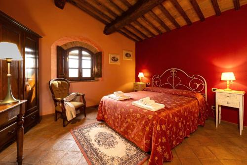 a red bedroom with a bed and a chair at Villa La Francigena in San Gimignano