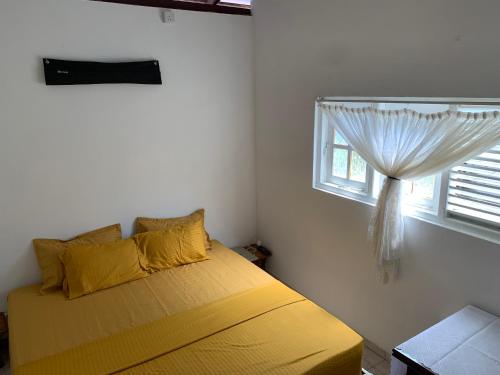 a bedroom with a yellow bed and a window at No 36 Surf Paradise Apartment in Matara