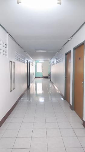 an empty hallway in a building with doors and a tile floor at Apartment near Central Festival Hatyai in Hat Yai
