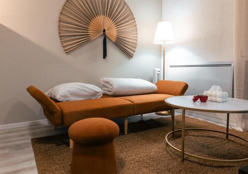 un salon avec un canapé et une horloge au mur dans l'établissement l'évidence-Bâle-Aéroport-Lockeys, à Saint-Louis