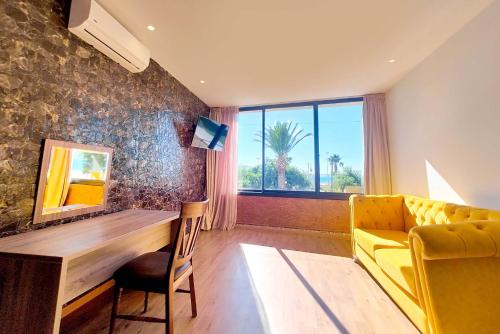 a living room with a yellow couch and a table at Villa Mirasol Hotel in Tangier