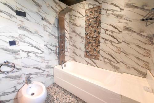 a bathroom with a bath tub and a sink at Villa Mirasol Hotel in Tangier