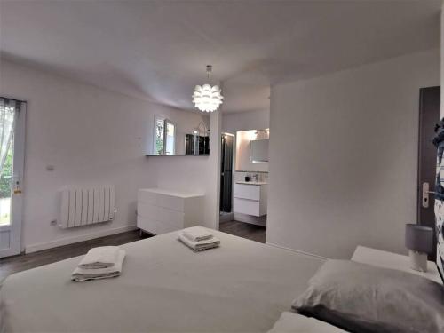 a white bedroom with a bed and a kitchen at Villa de plain-pied avec jardin et piscine privée in Grignan