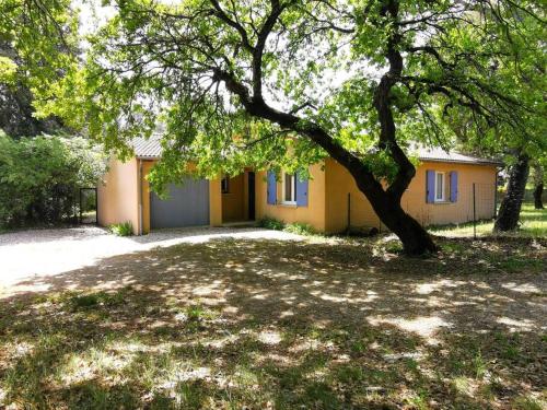 a yellow house with a tree in front of it at Villa de plain-pied avec jardin et piscine privée in Grignan