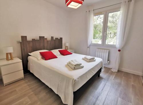 a bedroom with a large white bed with red pillows at Villa de plain-pied avec jardin et piscine privée in Grignan