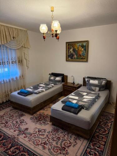 a bedroom with two beds and a chandelier at KRAICHGAU # 3-ZKB mit Balkon im EG, Monteurzimmer in Eppingen