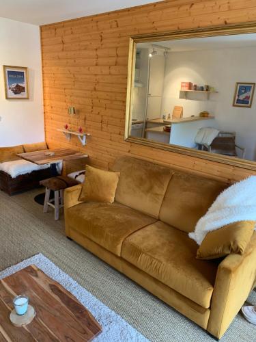 - un salon avec un canapé brun et un miroir dans l'établissement Isola 2000 appartement dans Chalet 4 ou 6 personnes grande terrasse, à Isola 2000