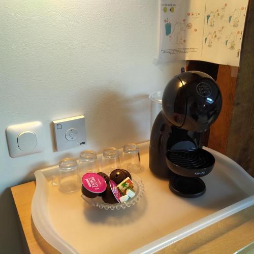 - une cafetière et des verres sur une table dans l'établissement Espace Beléverte Bussière 1 Tamaris appartement meublé de 2 chambres, à Oullins