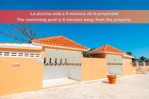 a house with two garage doors and a sign that reads la piscina c at Colinas del Atlantico Vacational House 2nd Floor in Isabela