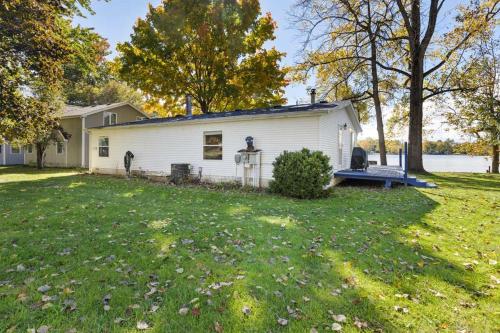 a white house with a yard with a grass yard at Lakefront Home with Dock Firepit & Private Deck in Grand Junction