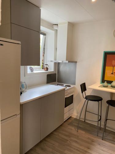 Una cocina con refrigerador y una mesa y sillas. en Vindmølle, en Stavanger