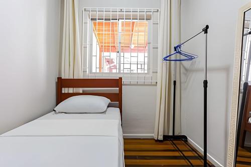 a small bedroom with a bed and a window at Casa central em ótima localização - UN059 in Florianópolis
