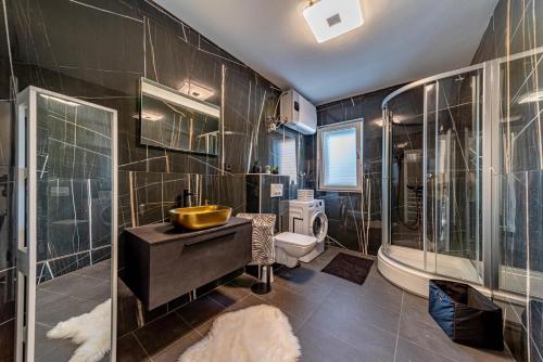 a bathroom with a sink and a tub and a toilet at Villa Franka with pool and sea view in Vela Luka