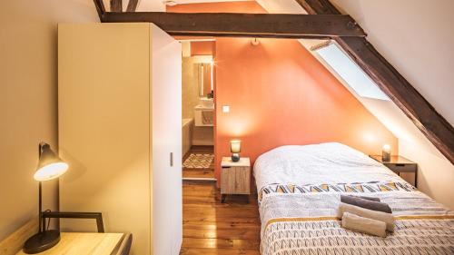- une chambre mansardée avec un lit et une fenêtre dans l'établissement Duplex Poincaré - Proche Hôtel de Ville - 4 pers, à Troyes