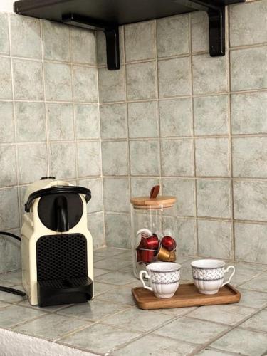 a kitchen counter with a coffee maker and some cups at Casa Elisa in Padru