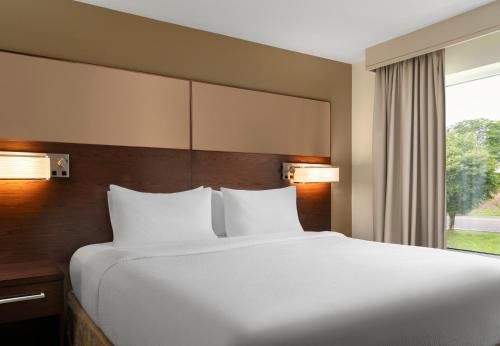 a large bed in a hotel room with a window at Residence Inn by Marriott Kingston in Kingston