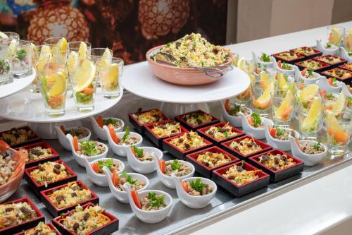 a buffet with many dishes of food on a table at Vila Gale Isla Canela in Isla Canela