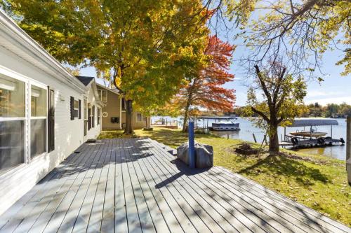 a house with a wooden deck next to a body of water at Lakefront Home with Dock Firepit & Private Deck in Grand Junction