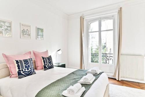 une chambre blanche avec un lit avec des serviettes dessus dans l'établissement Appartement parisien spacieux #Marais #Rivoli - II, à Paris
