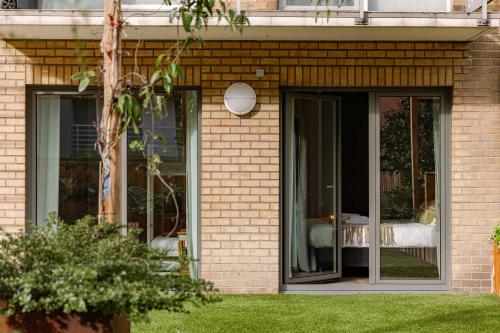 a brick house with sliding glass doors in a yard at Huswell - Seaview apartment with spacious terrace in Zeebrugge in Zeebrugge