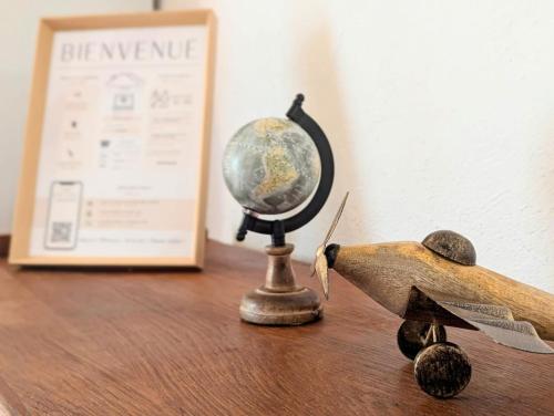 un petit avion de jouets assis sur une table à côté d'un globe dans l'établissement Le Cauris du pont romain, à Vaison-la-Romaine