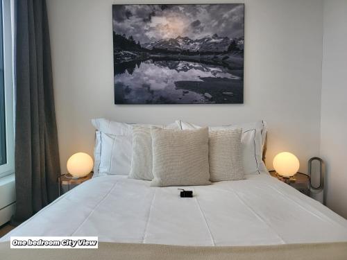 a bedroom with a large white bed with two lamps at Park Tower City View Apartments in Zug