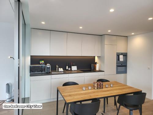 a kitchen with a wooden table and black chairs at Park Tower City View Apartments in Zug