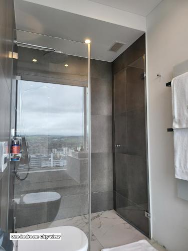 a bathroom with a shower with a glass door at Park Tower City View Apartments in Zug