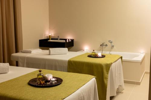 a hotel room with two beds and a bath tub at Vila Gale Isla Canela in Isla Canela