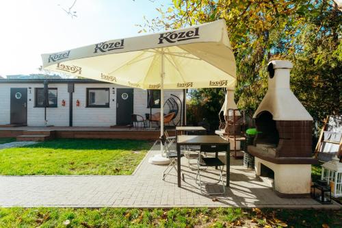 a patio with a table and an umbrella at Domki Wrocław in Wrocław