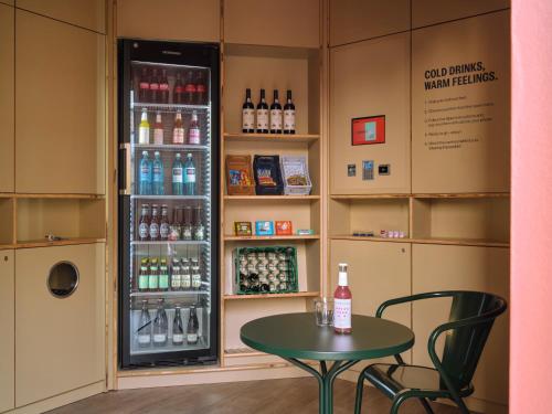 a room with a table and a drink refrigerator at STAYERY Cologne Sülz in Cologne