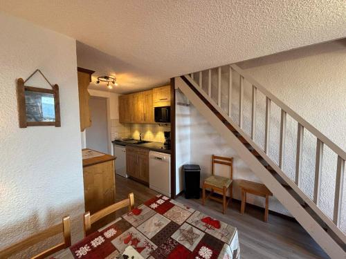 une petite cuisine avec une table et un escalier dans l'établissement Duplex 3P, 6 pers, balcon, TV, lave-vaisselle, animaux tolérés - FR-1-293-80, aux Saisies