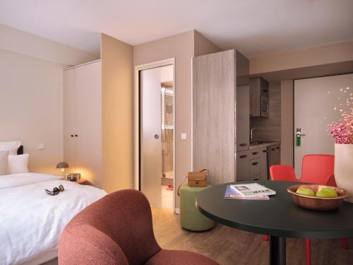 a hotel room with a bed and a table and chairs at STAYERY Cologne Sülz in Cologne