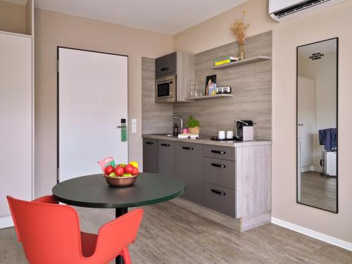a kitchen with a table and a bowl of fruit on it at STAYERY Cologne Sülz in Cologne
