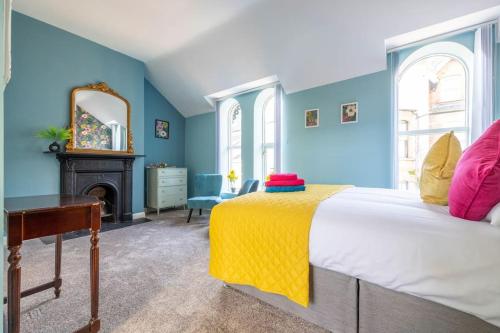 a bedroom with a bed with a yellow blanket on it at Boutique Homes At 4 in Bangor