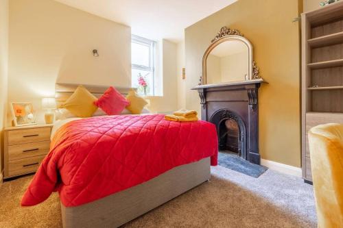 a bedroom with a red bed and a fireplace at Boutique Homes At 4 in Bangor