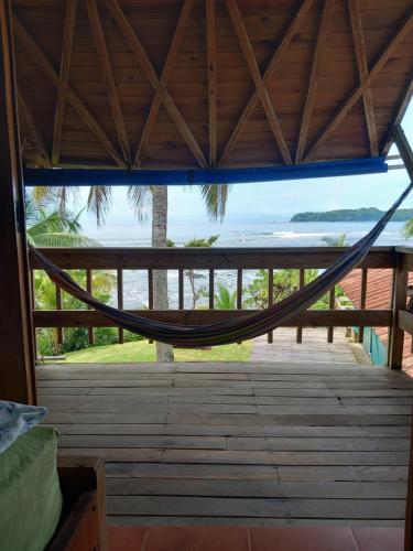 a hammock in a room with a view of the ocean at Hostal Surfers Paradise in Santa Catalina