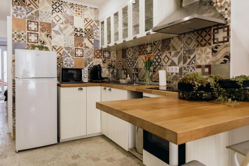 a kitchen with white cabinets and a white refrigerator at Dandy's Blue Apartments in Setúbal